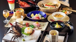 A variety of dishes and a lobster on a table, suggesting a seafood meal setting.