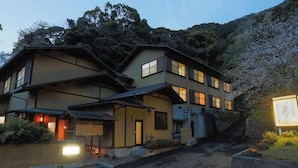 A traditional Japanese-style building with multiple floors, large windows, and a sloped roof.