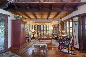 Une pièce chaleureuse avec un plafond en bois, un canapé, une table et un fauteuil à bascule.