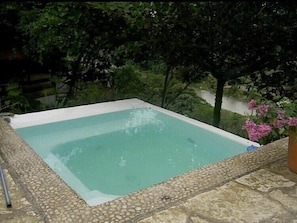 A rectangular swimming pool with a pebble-lined edge, surrounded by greenery and a stone deck. - Jarabacoa Dream Paradise Eco Lodge  #1 La Casona! (Jarabacoa)