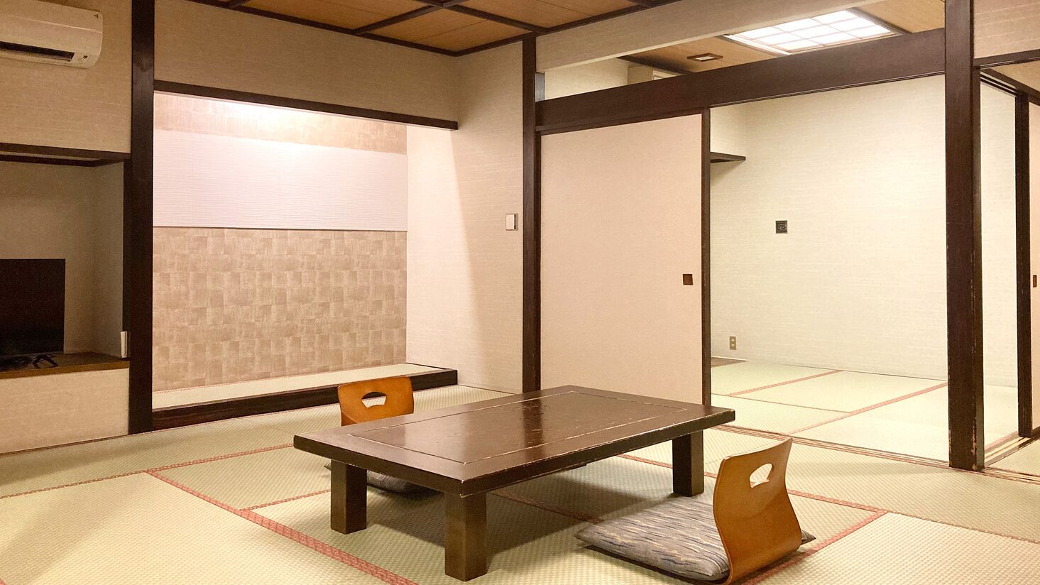 A traditional Japanese room with tatami flooring, a low wooden table, and sliding doors.