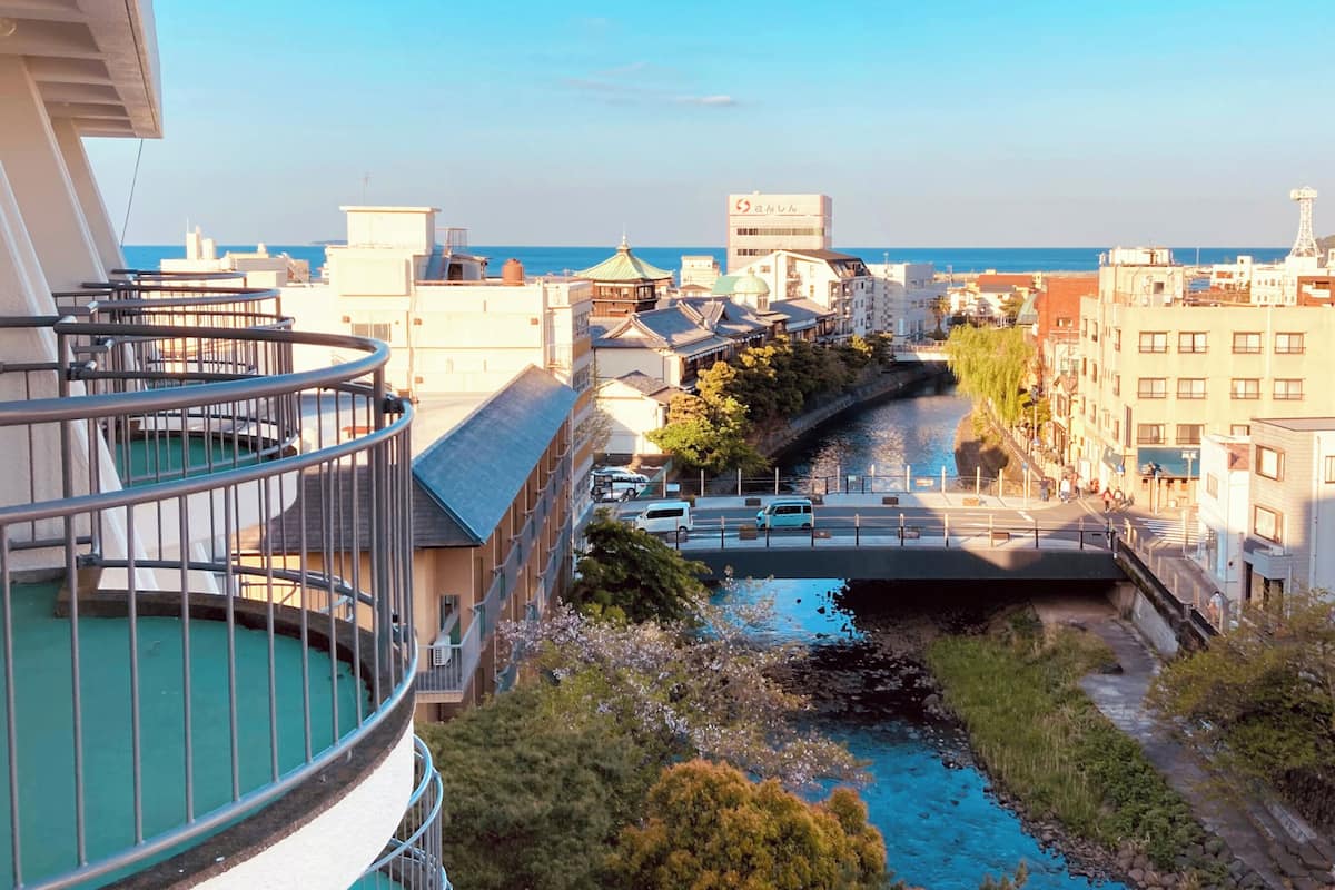 A riverside view with buildings, a bridge, and a clear sky.