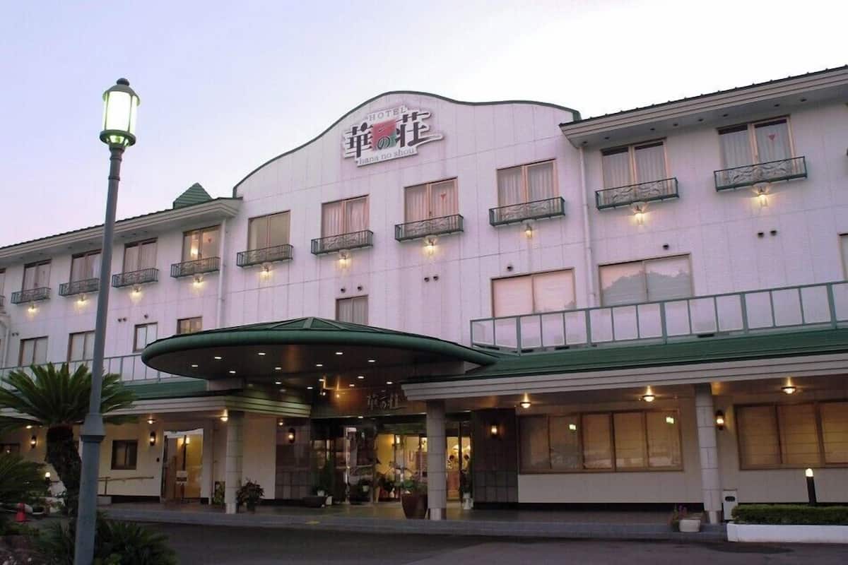 A hotel with a curved facade, multiple balconies, and a covered entrance area.