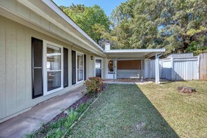A house with a covered porch, a small garden, and a wooden fence.