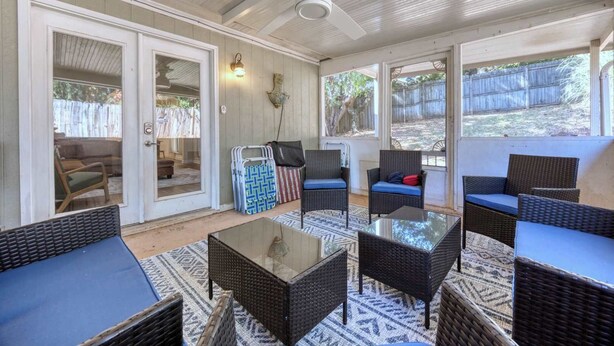 An open patio with wicker furniture, a glass table, and a ceiling fan. - Near the Hospital and Dining - Sunrise Knoll Stay (Columbus)