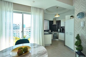 Un apartament modern amb zona de menjador, cuina i vistes a la ciutat.