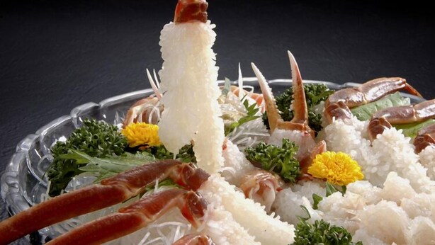 A dish with rice, crab legs, and greens.