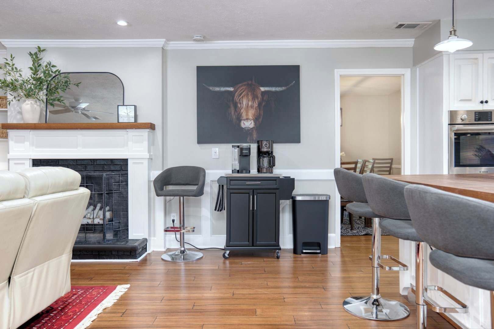 Un salon moderne avec une cheminée, un coin repas et une cuisine.