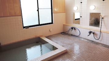 Un baño con bañera, ducha y ventana.
