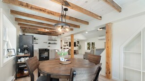 Een eethoek met een houten tafel, stoelen en een hanglamp.