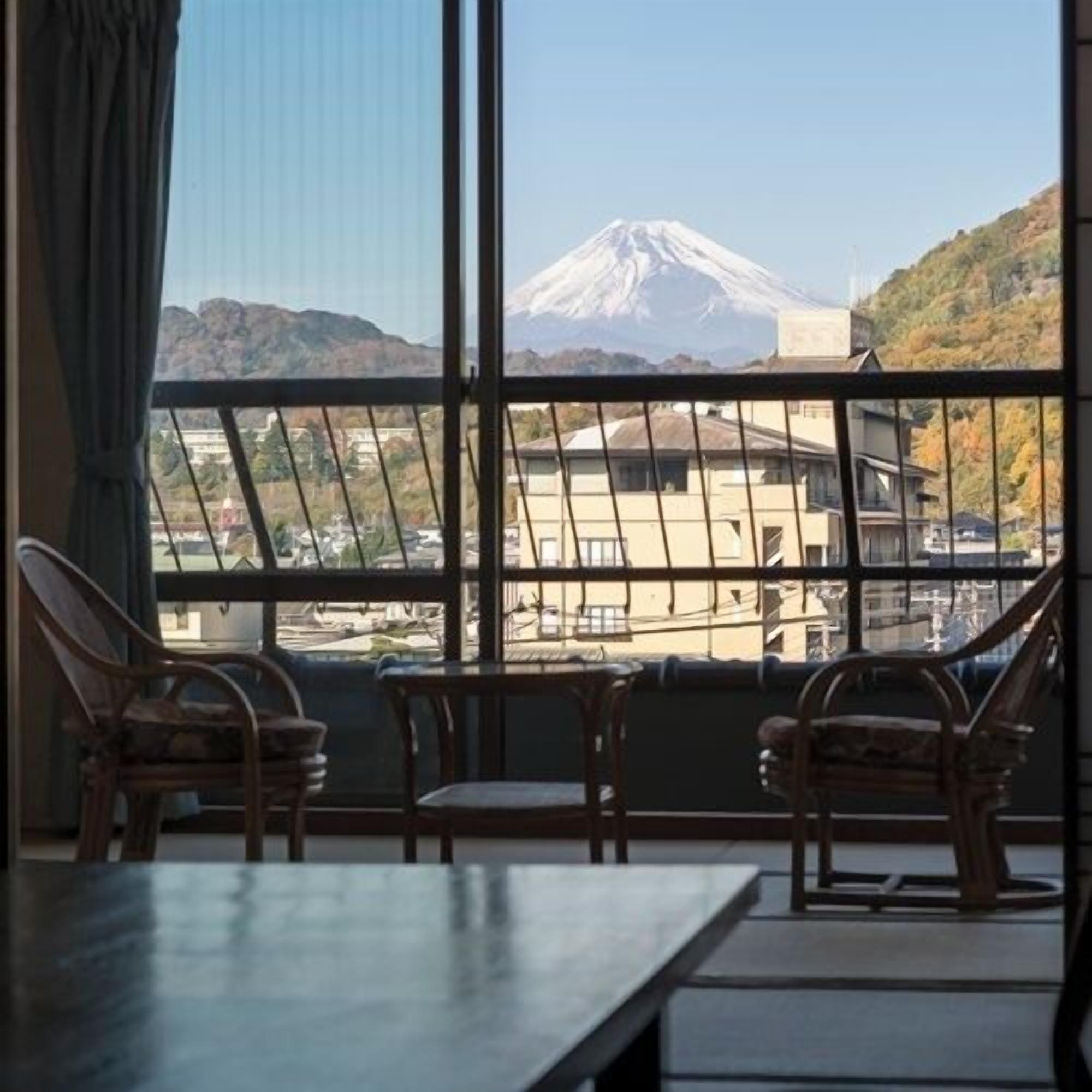 Ein Zimmer mit Blick auf einen Berg, zwei Stühle und ein Tisch.