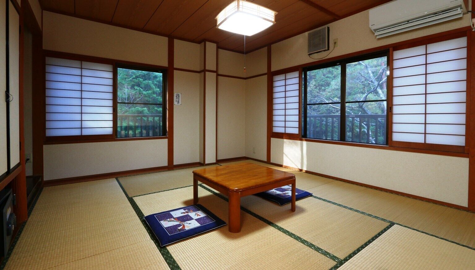 Ein traditioneller japanischer Raum mit Tatami-Bodenbelag, einem Holztisch und Shoji-Schirmwänden.