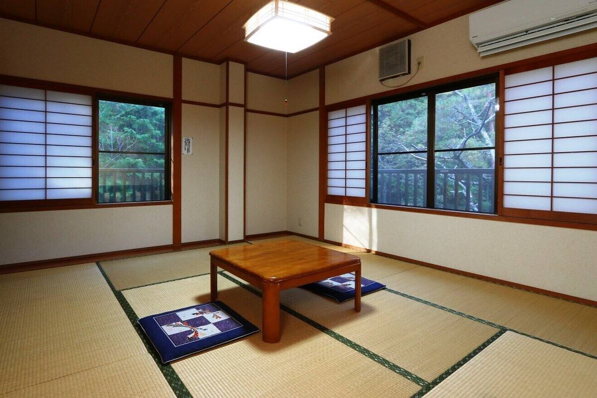 A traditional Japanese room with tatami flooring, a wooden table, and shoji screens.