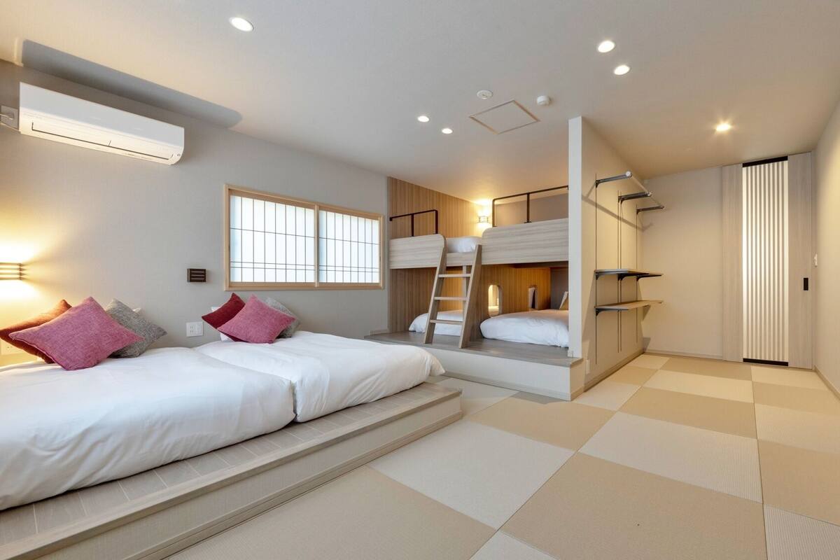 A room with bunk beds, a window, a ladder, and a sliding door.