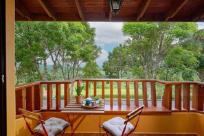 Un terrazzo in legno con vista su un paesaggio verde e rigoglioso.