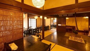 A traditional Japanese restaurant interior with tatami mats, wooden furniture, and shoji screens.