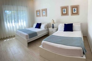 A hotel room with two beds, a nightstand, a lamp, and framed artwork on the wall. - ®{Samán~Experience}@Terrenas +Pool+BBQ+5 Min Beach (Las Terrenas)