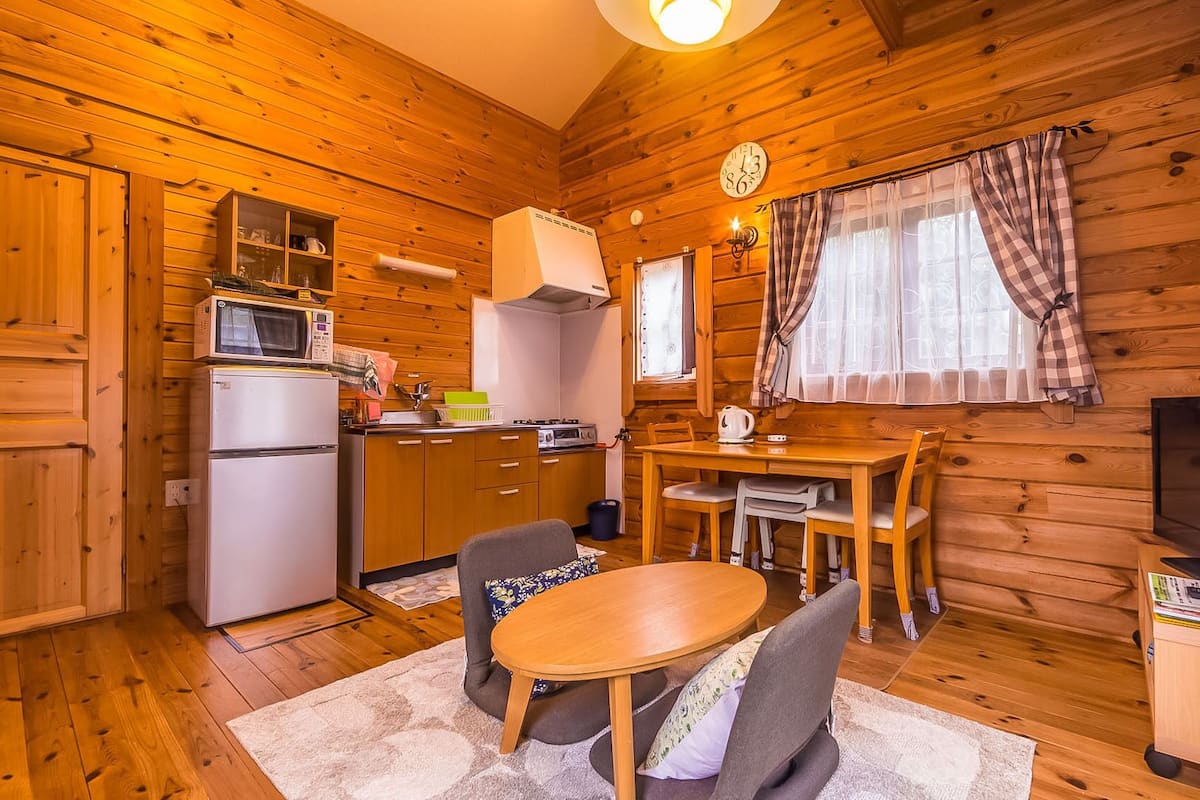 A cozy cabin interior with a kitchen, dining area, and a television.
