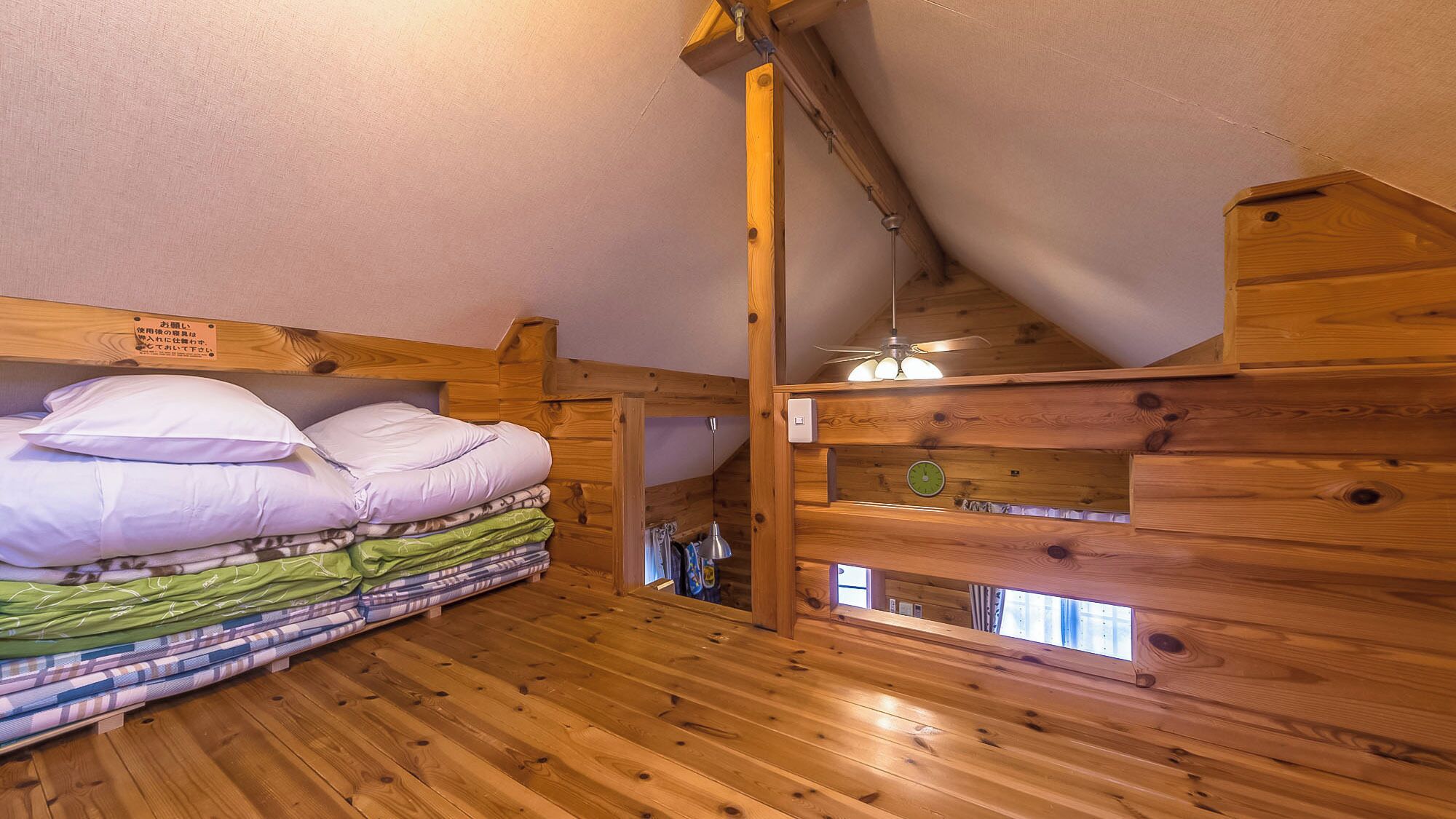 A wooden cabin room with a bunk bed, a wooden ceiling, and a small window.