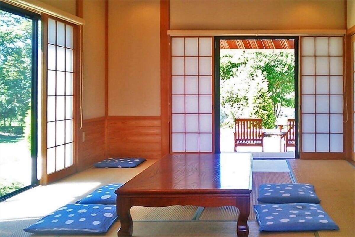A traditional Japanese room with tatami flooring, a low wooden table, and shoji screens.