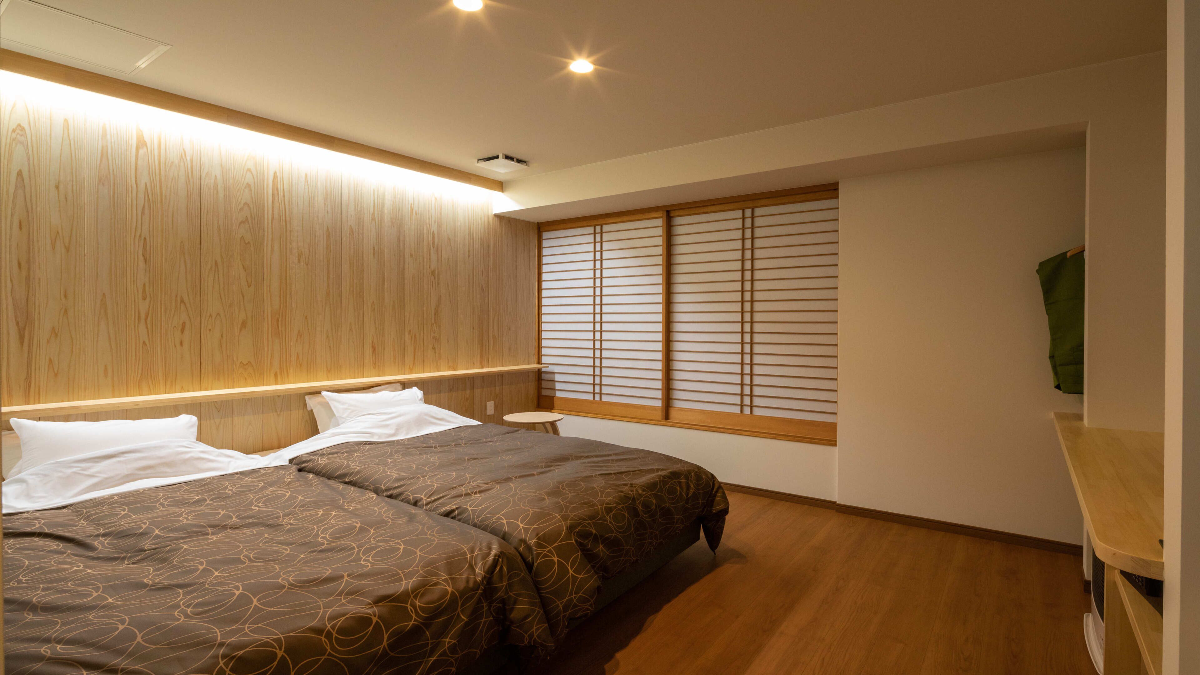 Camera da letto con un letto, comodini, una finestra con tende e una testiera in legno.