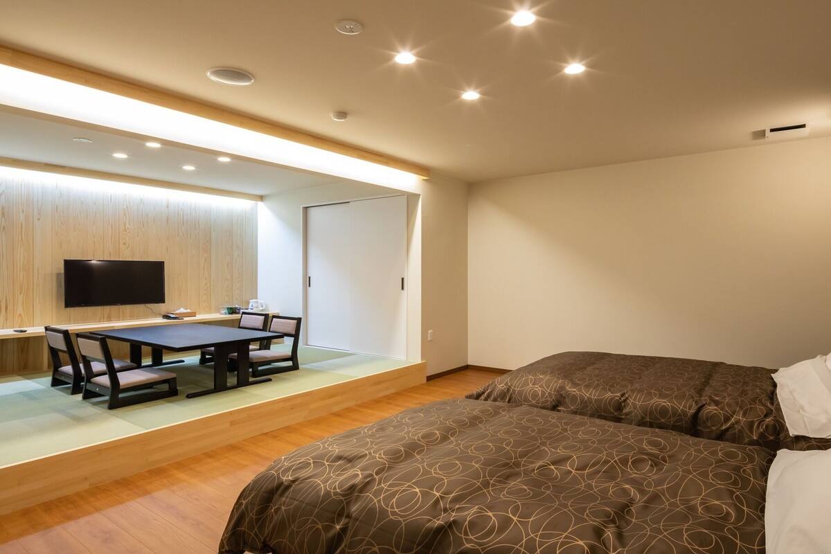 Une chambre d’hôtel comprenant un lit, un bureau avec une chaise, une télévision et une porte coulissante.