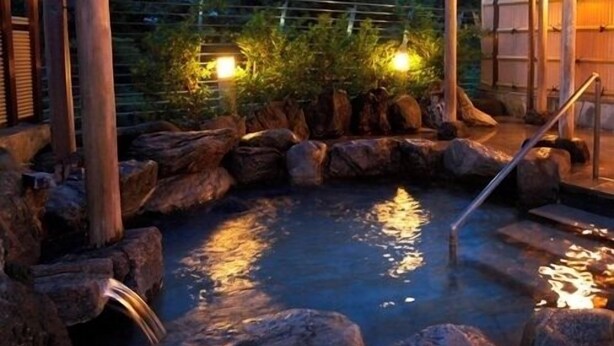 A traditional Japanese onsen with a wooden structure, a rock-lined hot spring, and a wooden walkway. - Shiganosato Onsen Ikoinomura Notohantou (Shika)