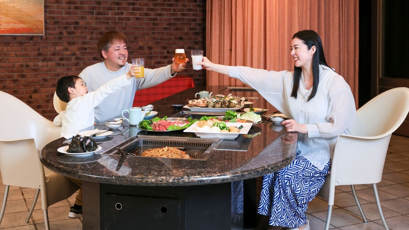 A group of people toasting around a table with various dishes and drinks.