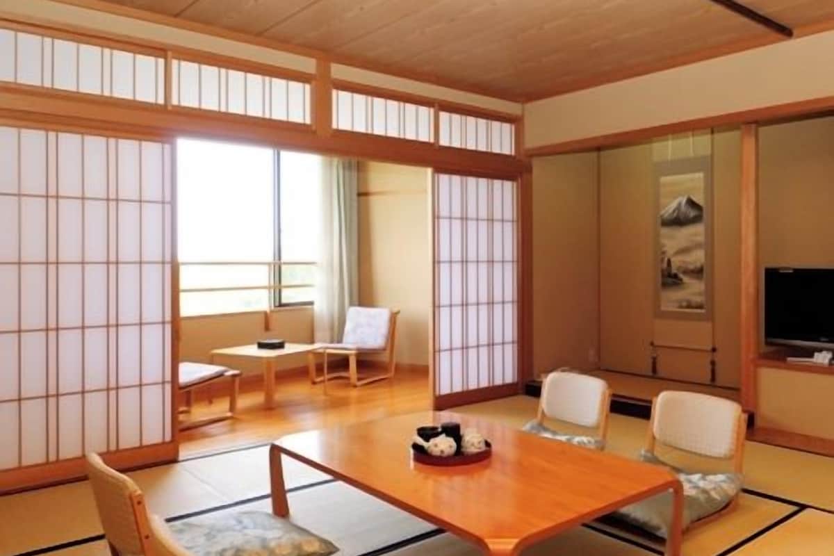 A traditional Japanese-style room with tatami flooring, a low wooden table, and shoji screens.
