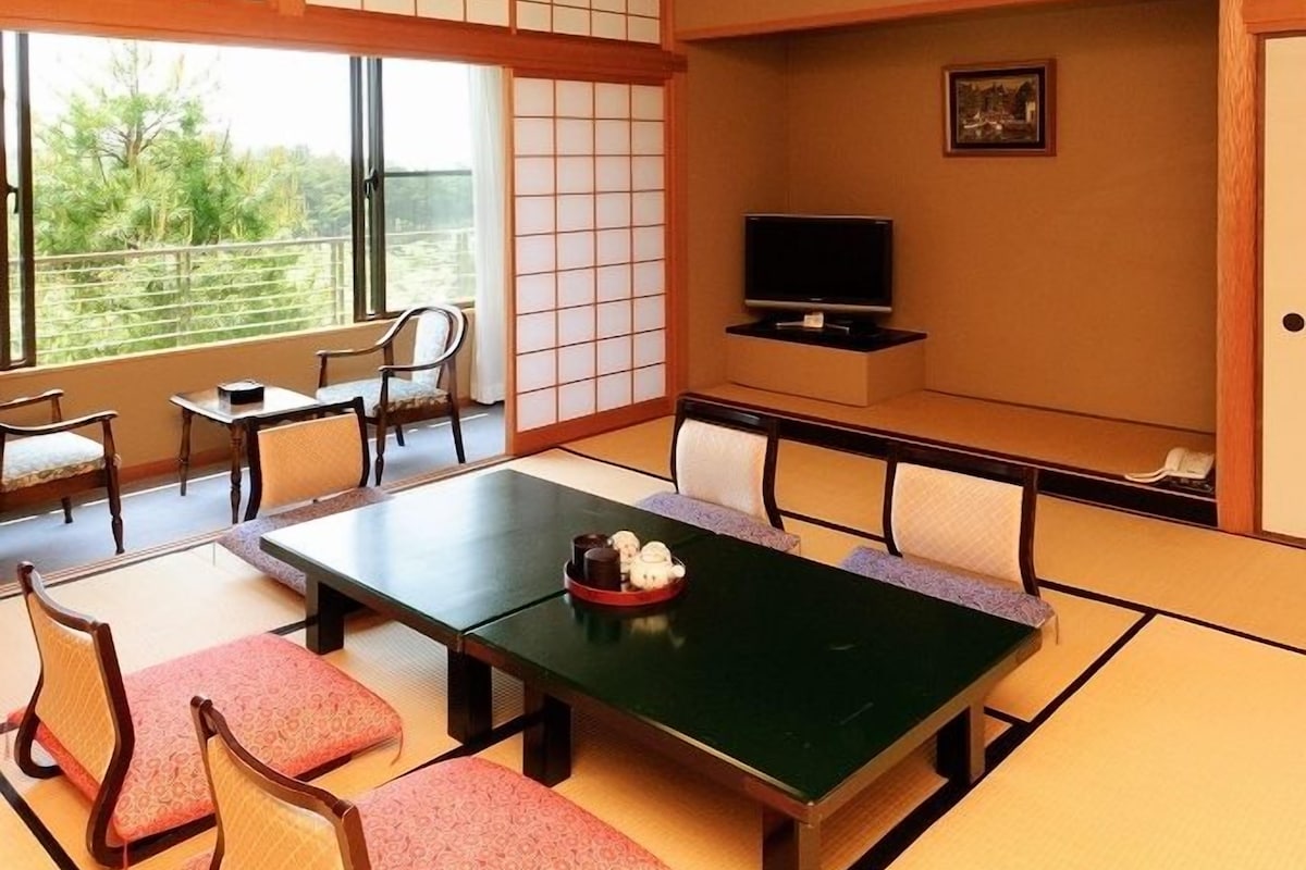A traditional Japanese-style room with tatami flooring, a low table, and shoji screens.