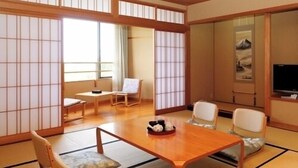 A traditional Japanese-style room with tatami flooring, a low wooden table, and shoji screens. - Shiganosato Onsen Ikoinomura Notohantou (Shika)