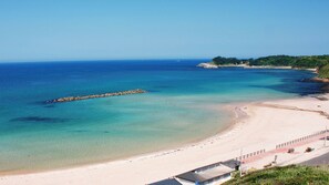 A coastal beach with clear waters, a sandy shore, and a rocky breakwater. - Minshuku Katsumaruso <ikinoshima> (Iki)