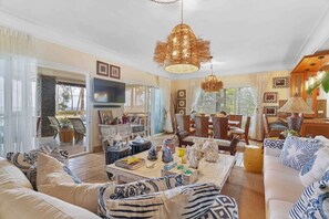 A spacious living area with a large sofa, a dining table, and a TV mounted on the wall. - ®3BR{Beach~Essence}@Terrenas +Pool+Maid+Beachfront (Las Terrenas)