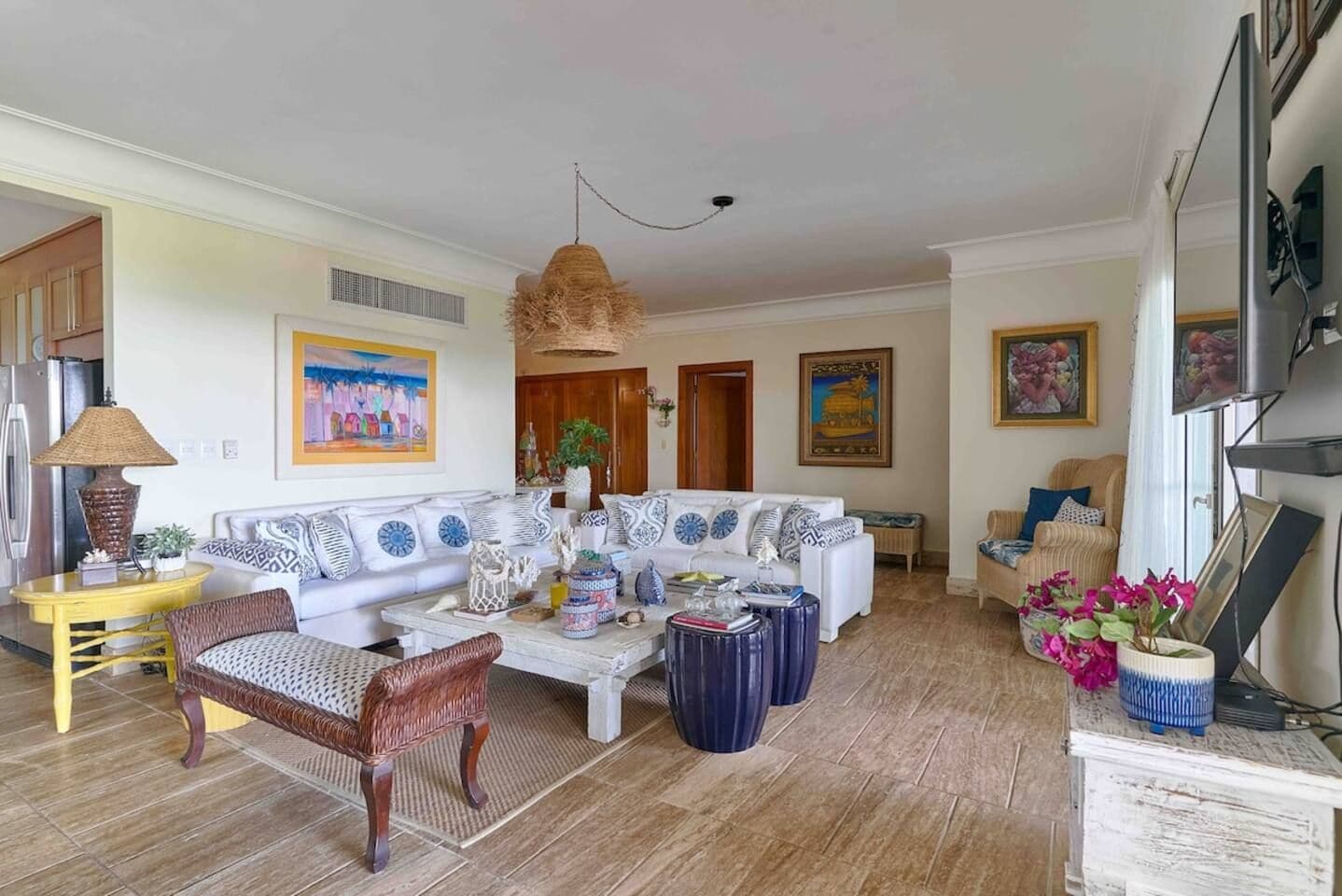 Een woonkamer met een bank, fauteuils, een salontafel en een televisie.