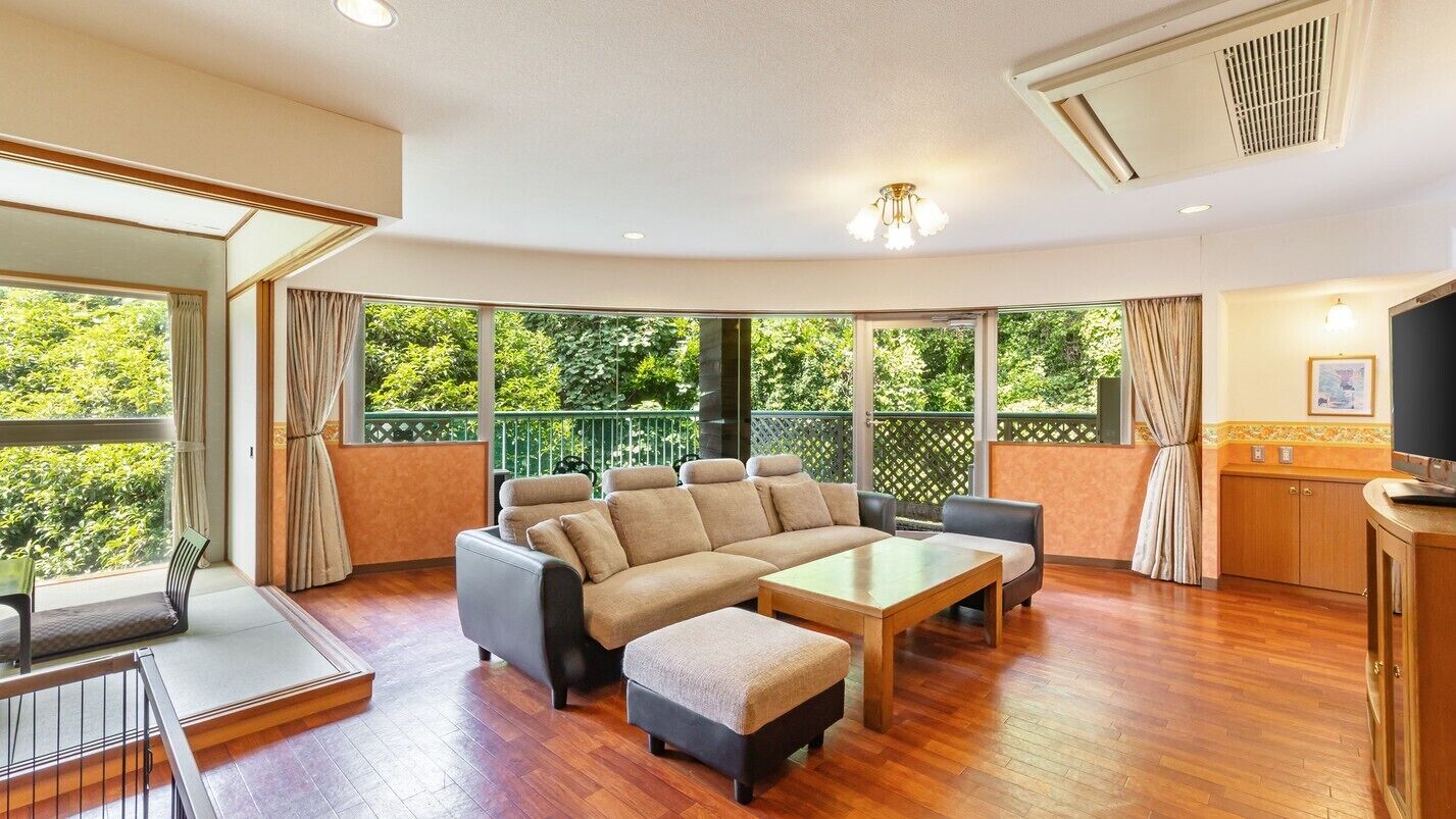 A modern living room with a sectional sofa, a coffee table, and a TV.