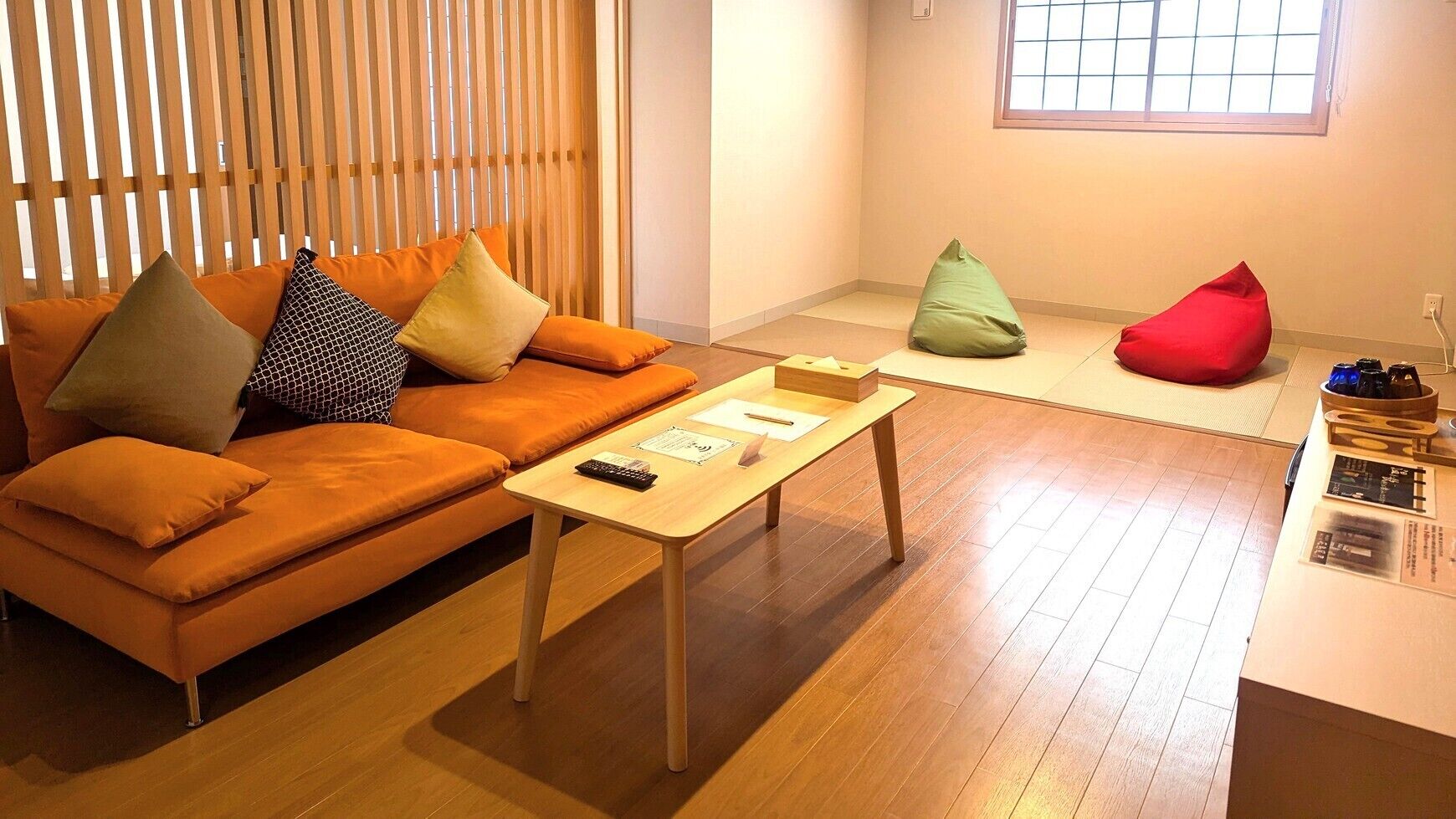 A modern living room with a sofa, a coffee table, and a red bean bag.