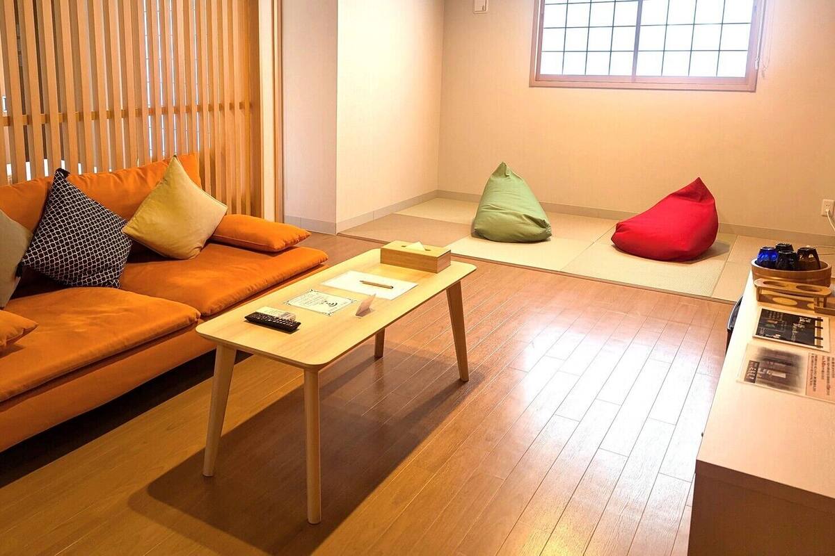 Un salon moderne avec un canapé, une table basse et un fauteuil en forme de poire rouge.