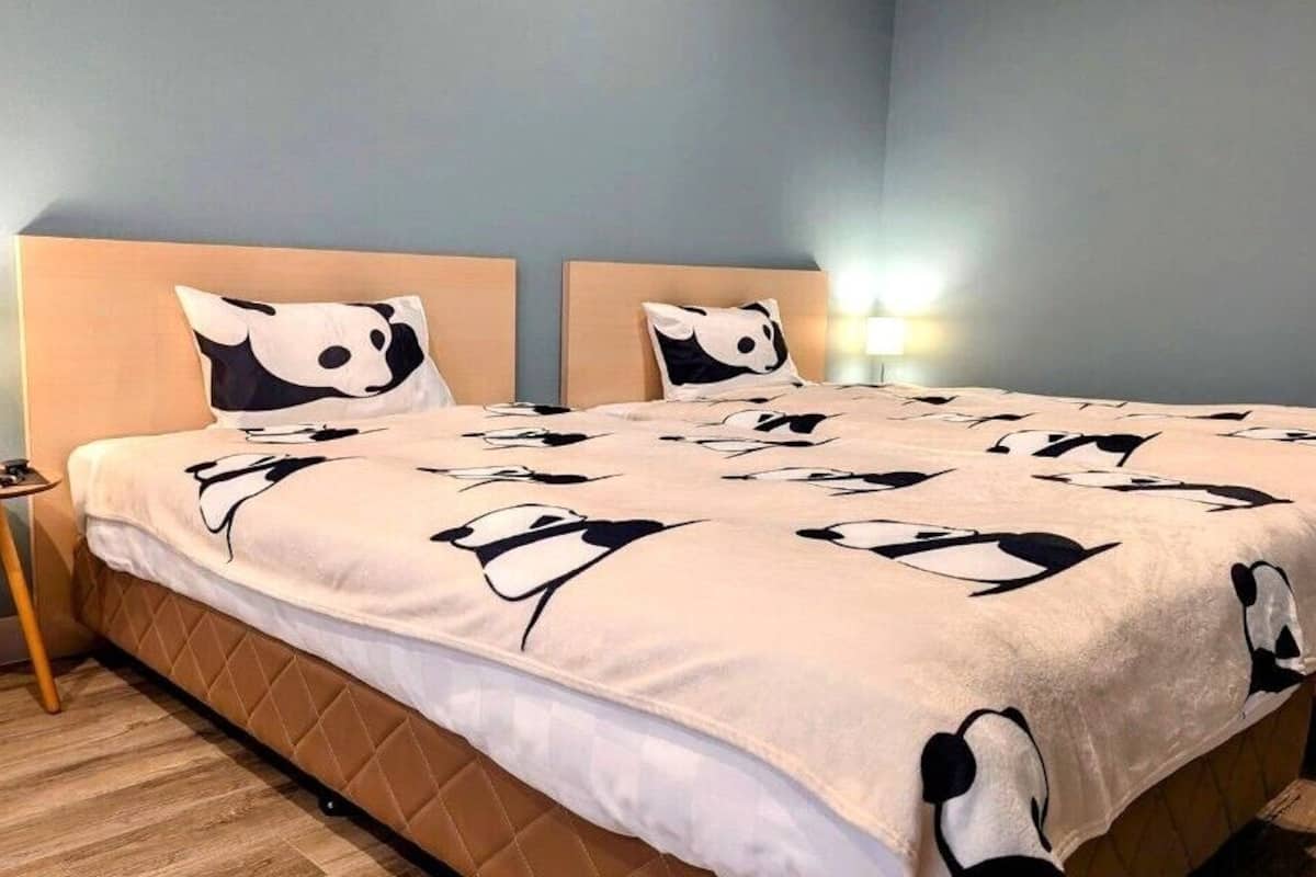 Une chambre à coucher avec un lit, deux lampes de chevet et une petite table avec une lampe.
