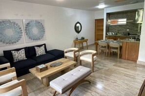 A living room with a sofa, chairs, a coffee table, and a dining area with a kitchen in the background. - ®{Terrenas~Beach~Spot} Monserrat +Pool+5min Beach (Las Terrenas)