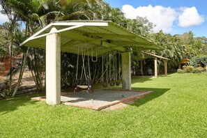 A covered outdoor seating area with swings, surrounded by lush greenery and palm trees. - ®{Villa~Roseca~EcoLodge}@LosMogotes +Pool+Family (Dominican Republic)