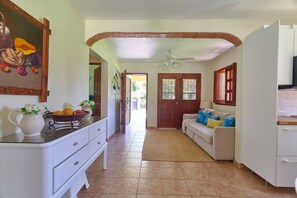 A spacious kitchen with a dining area, a white refrigerator, and a ceiling fan.