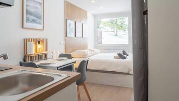 Tabla de planchar con plancha y ropa de cama