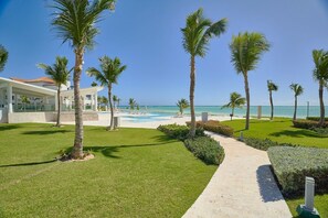 A resort with a pool, palm trees, and a pathway leading to a building. - ®The{Beach~Spot} @CapcanaParadise +Pool+Beachfront (Punta Cana)