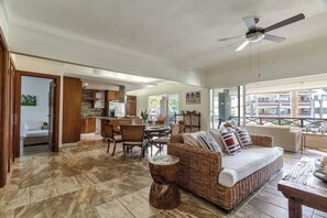 A spacious living area with a dining table, wicker sofa, and a ceiling fan. - ®{The~beach~condo} @Balcones del Atlantico (El Limón)