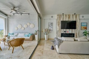 A modern living room with a sofa, a television, and decorative wall art. - ®{Costa~Sol~Views} @JuanDolio +Pool+Beachfront (Playa Juan Dolio)