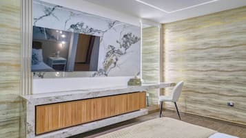 Un baño moderno con tocador de mármol, un espejo grande y un armario de madera.