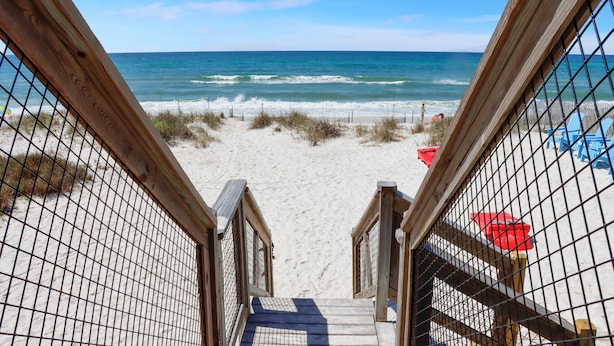 A wooden staircase leading to a beach with a view of the ocean. - My Tide (Port St. Joe)