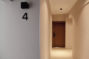 A hallway with a number '4' sign, a wooden door, and a recessed ceiling light. - ®2BR{Santorini~Views} @Downtown SDQ +Lounge+Gym (Santo Domingo)