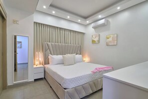 A modern bedroom with a large bed, bedside lamps, an air conditioning unit, and a view of the hallway. - ® {Art~City~View} @Downtown SDQ +Pool+Gym+KingBed (Santo Domingo)