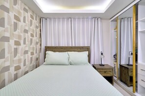 A bedroom with a bed, nightstands, a mirror, and a ceiling light. - ®{San~Angel~View} @DowntownSD +BBQ+Close-to-Mall (Santo Domingo)